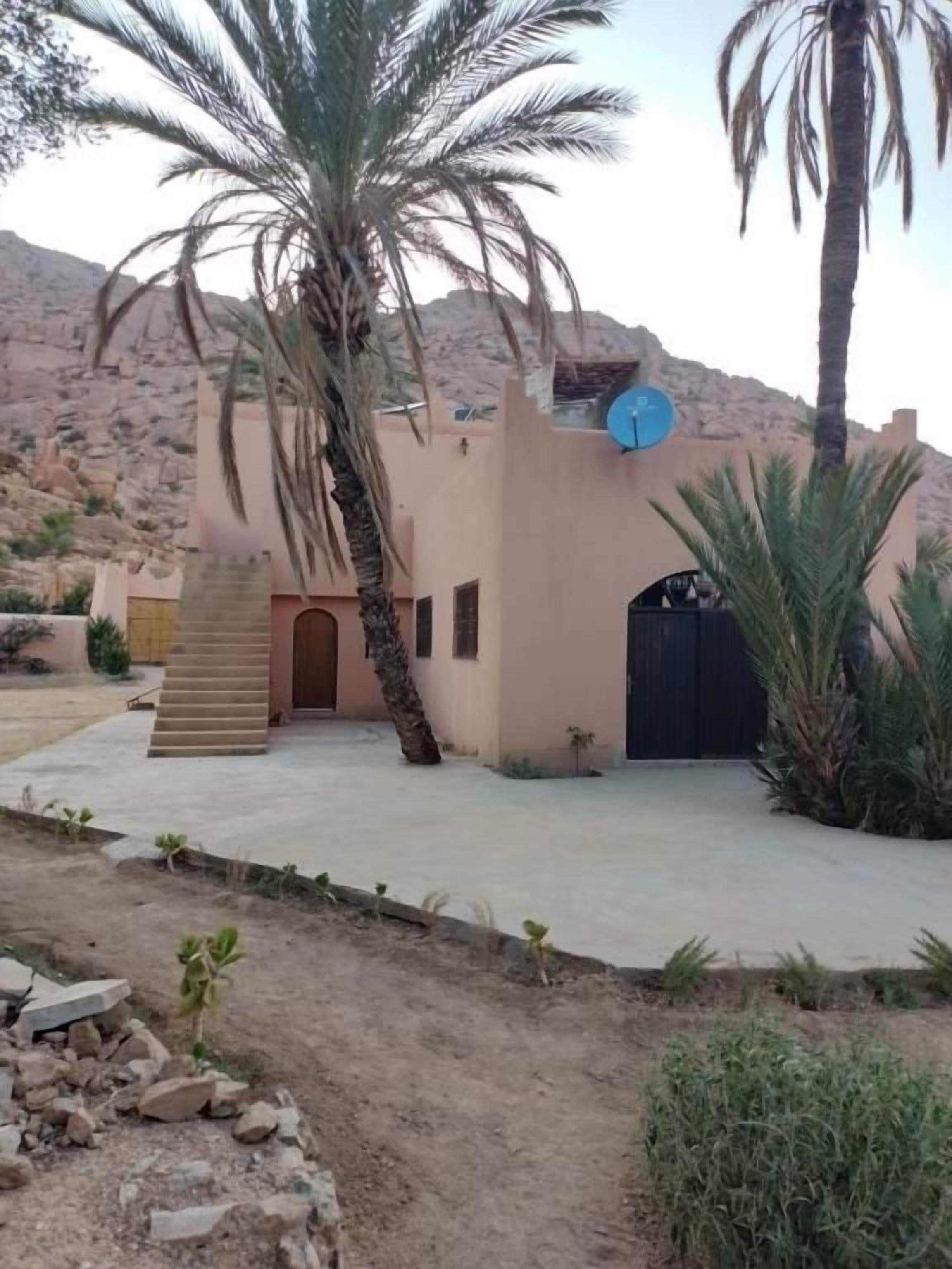 A building with a flat roof, a satellite dish, and a gated entrance.