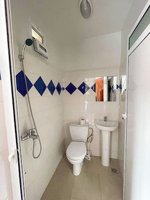 Ein Badezimmer mit Dusche, Toilette und Waschbecken.
