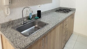 Cafetera o tetera, microondas, lavavajillas y utensilios de cocina