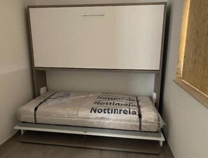 A room with a bed, a wardrobe, and a mattress with a brand name. - Amida App.to, Cielo, 1st Floor (Campomarino di Maruggio (TA))