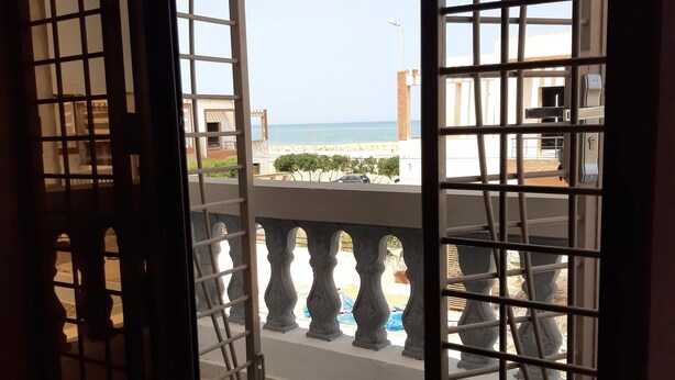 A view from a balcony with metal railings and a tiled floor.