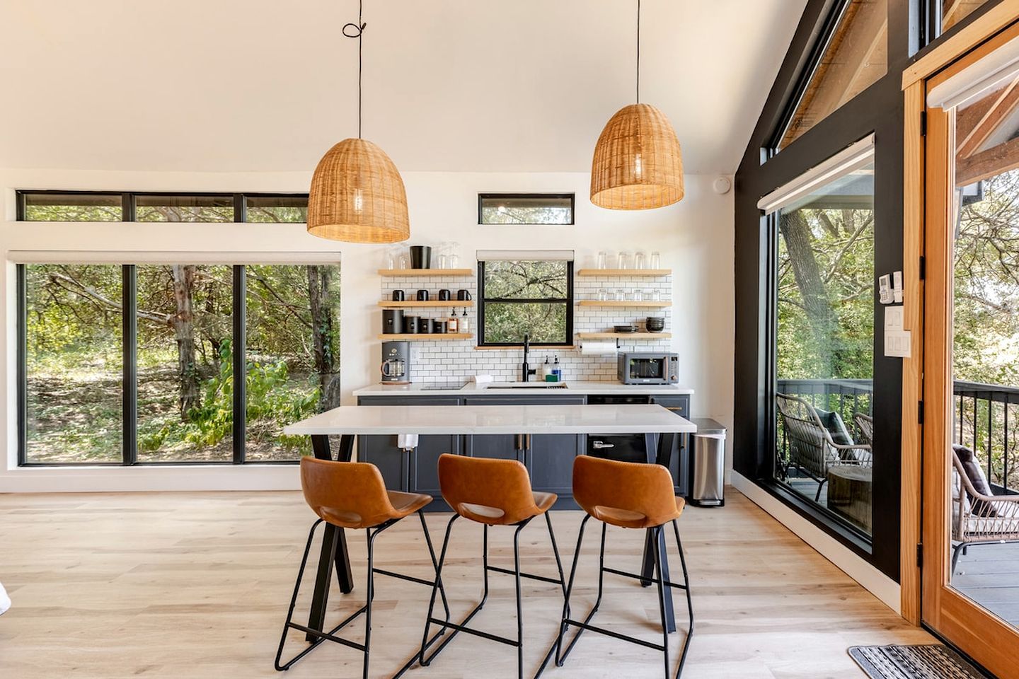 Una cocina moderna con una isla central, taburetes de bar e iluminación colgante.