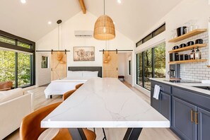 Una cucina moderna con un'isola grande, mobili in legno e vista sull'esterno.