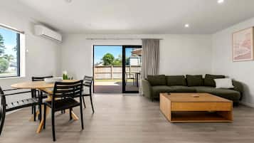 A modern living room with a dining area, a sofa, and a coffee table.