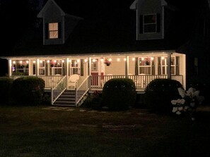 A two-story house with a front porch, a staircase, and a small front yard. - Charming Dog-Friendly Beach House with Fire Pit & Jetted Tub Near Carters Beach in Hancock, Maine (Hancock)