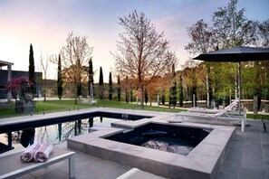 A modern outdoor pool area with lounge chairs and a hot tub. - Amazing Villa with Swimming Pool and Lake Access in Hepburn, Victoria (Hepburn)