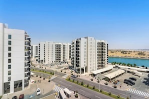 Un complesso residenziale moderno con diversi edifici di appartamenti, un'area di parcheggio e vista su un corpo d'acqua.
