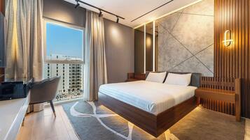 A modern hotel room with a large bed, a desk, a chair, and a view of the cityscape.