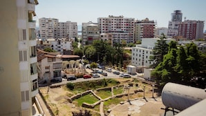 A residential area with modern buildings, a parking lot, and a historical site with ruins. - Rooftop Apartment w Garden Jacuzzi (Durrës)