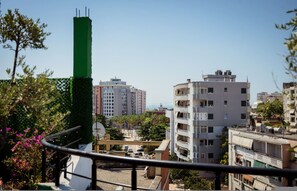 Ein Wohngebiet mit mehrstöckigen Gebäuden, einer vertikalen Grünanlage und einem Balkon mit Geländer.