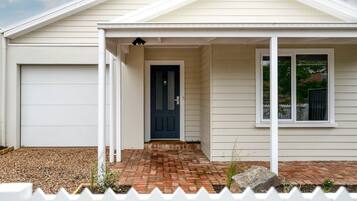 A house with a garage, a covered porch, a front door, and a window.