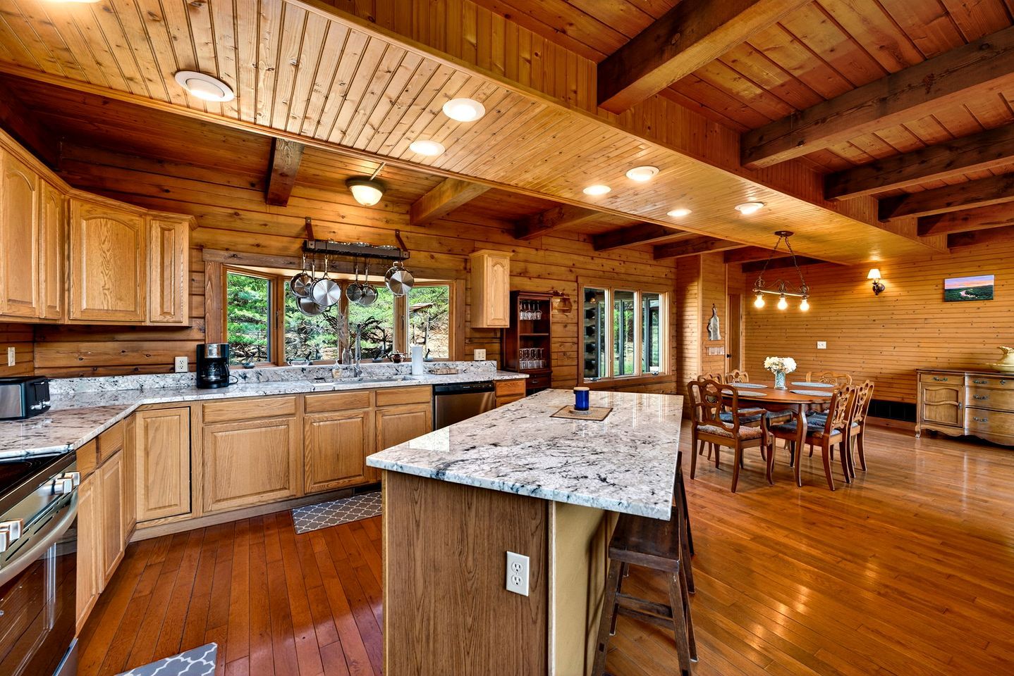A spacious kitchen with wooden cabinets, granite countertops, and a central island.