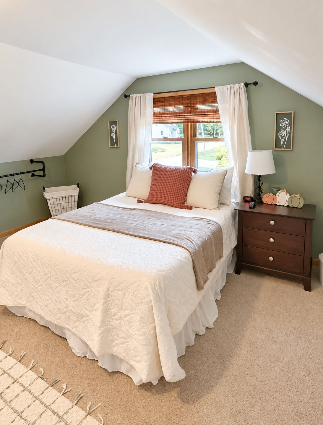Une chambre à coucher avec un lit, une table de chevet, une lampe et une fenêtre avec des rideaux.