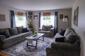A living room with two sofas, a coffee table, and a patterned rug.