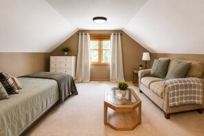A bedroom with a bed, a sofa, a nightstand, a window with curtains, and a ceiling light.