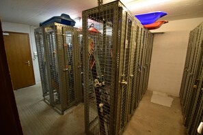 Ein Lagerraum mit Metallschließfächern, einer Holztür und einem blauen und roten Gegenstand an der Decke.