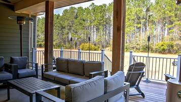 A covered outdoor seating area with a view of a forest.
