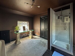 Een aparte badkuip en douche, een haardroger, handdoeken, zeep