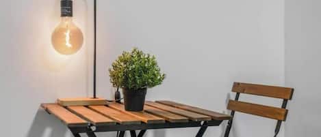 Une table avec une plante en pot et une ampoule suspendue.