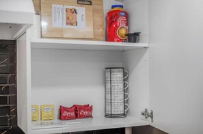 A kitchen with a coffee maker, a cutting board, and a coffee can. - Cozy Niagara Retreat with Fireplace (Thorold)