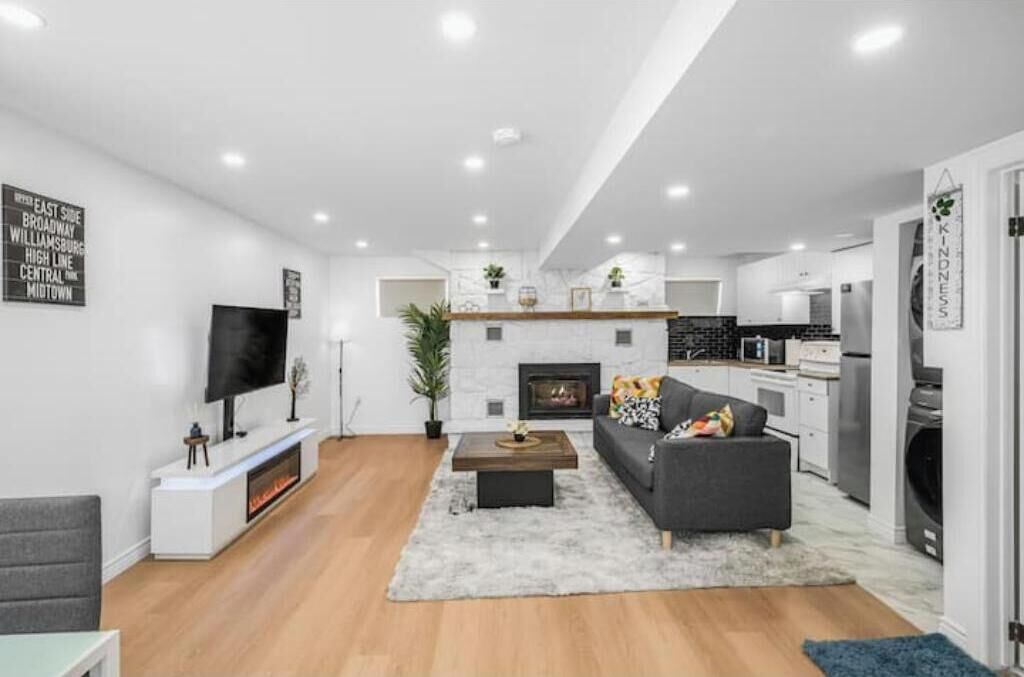 A modern living room with a fireplace, a flat-screen TV, a sofa, and a coffee table.
