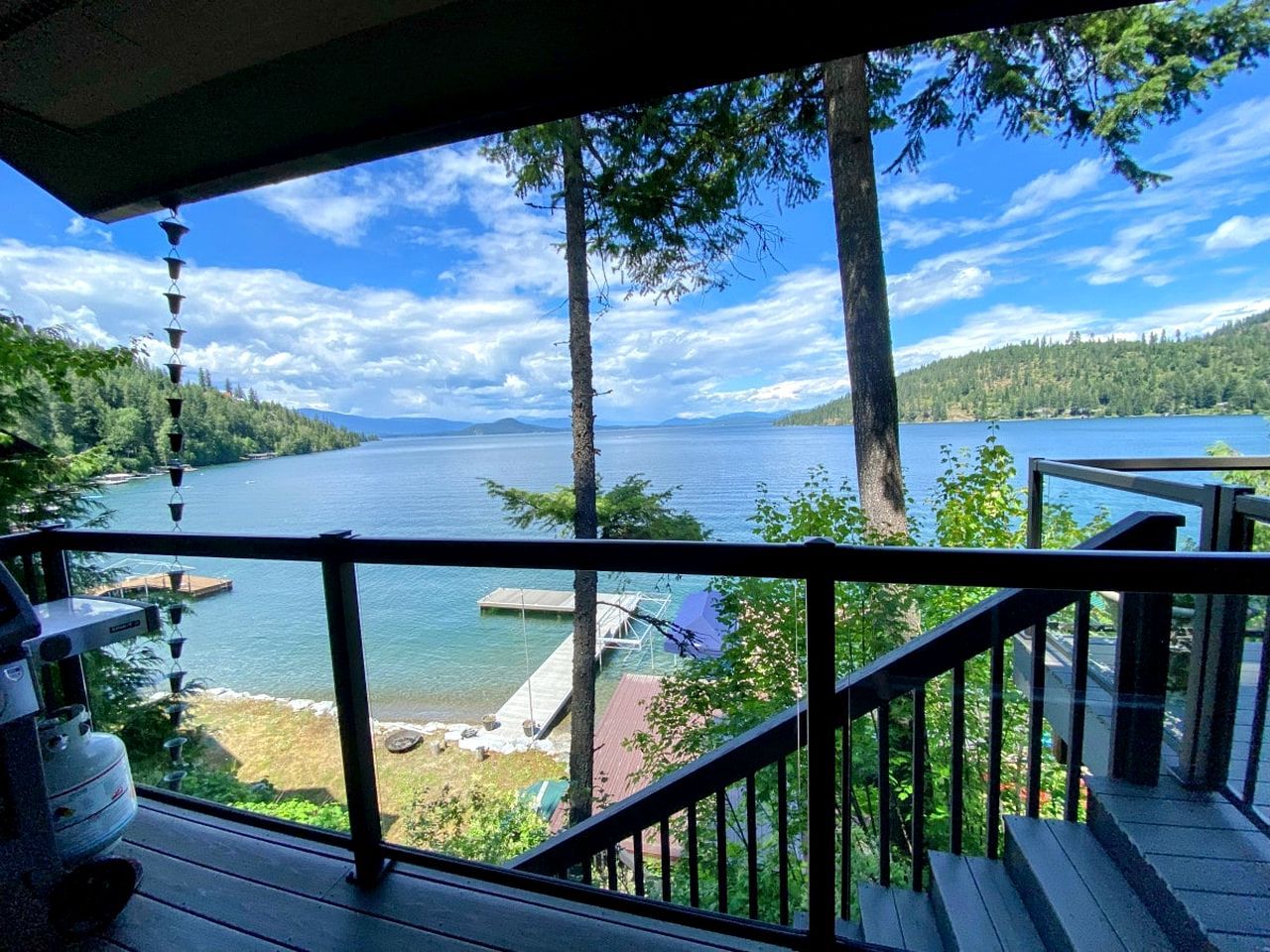 A deck with a view of a lake and forest.