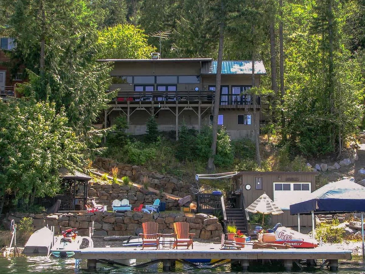A waterfront property with a dock, boats, and outdoor seating.