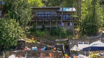 A waterfront property with a dock, boats, and outdoor seating.