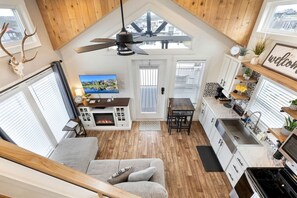 Un espace de vie de style loft comprenant une cheminée, un coin repas et une cuisine équipée d’un évier et d’une cuisinière.