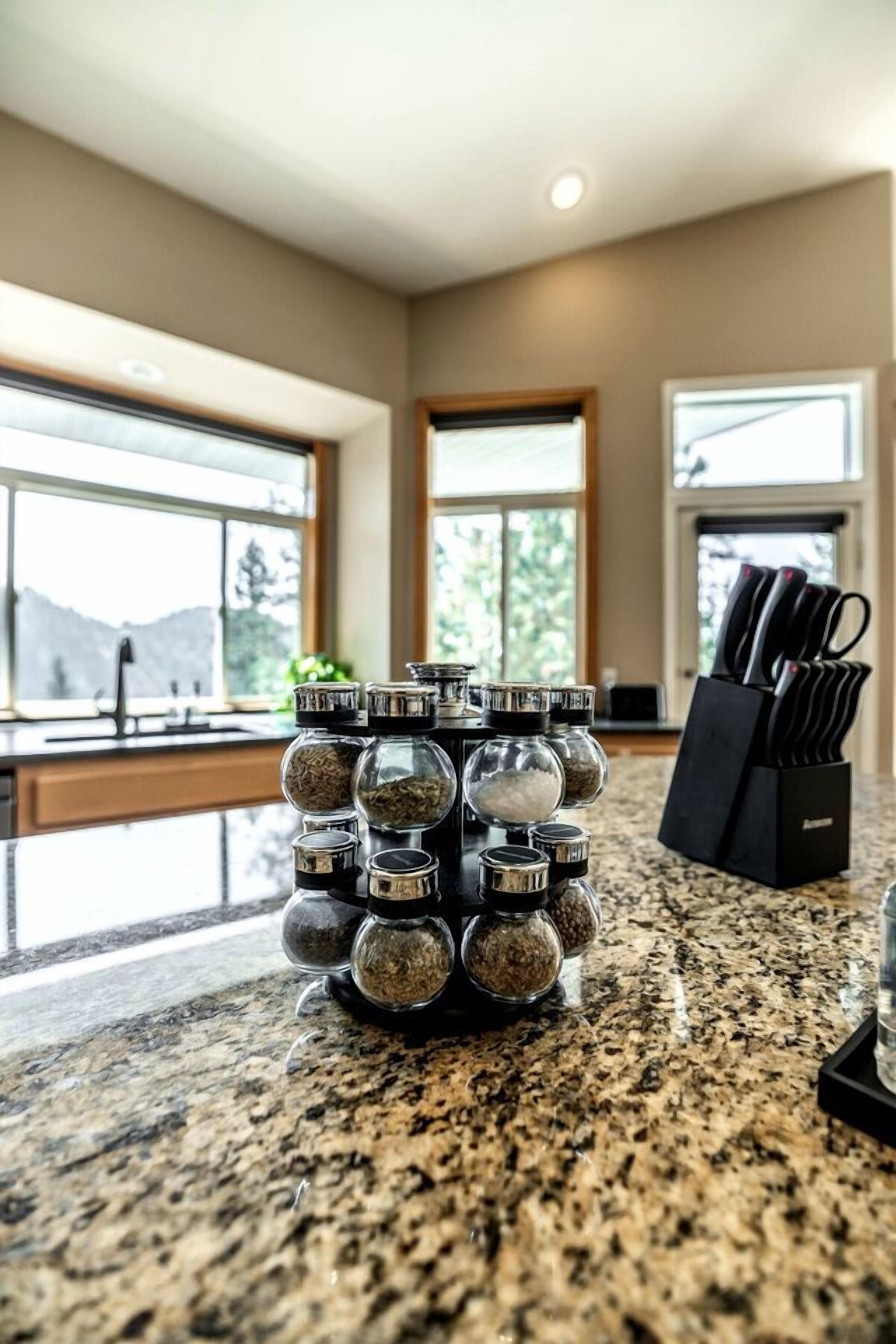 A kitchen counter with a spice rack and a knife block.