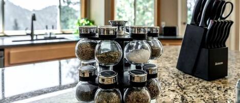 A kitchen counter with a spice rack and a knife block.