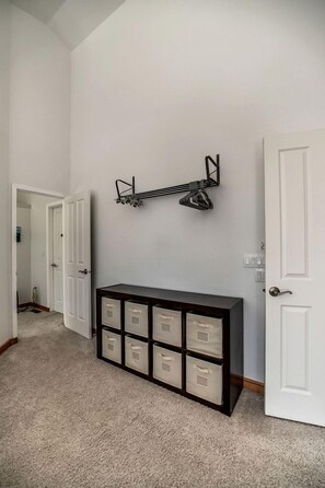 A hallway with a dark wooden console table with storage drawers, a white door on the right, and a white door at the end of the hallway. - Enchanting Vacation Rental with Breathtaking Lake Views near Lake Fernan in Idaho (Coeur d'Alene)