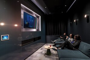 A modern cinema room with a large screen, reclining seats, and a control panel. - Student Only Verde Newcastle (Newcastle upon Tyne)