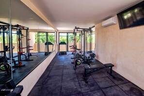 A gym with exercise equipment, a bench, and a large mirror. - Enjoy Tulum from Athara by HEUSHAVEN, a modern apartment in La Veleta, next to Central Park Lagunas. Ideal for couples or relaxed getaways, with a private pool, equipped kitchen, WiFi and amenities to unwind after the beach. (Tulum)