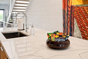 Eine Küchenarbeitsplatte mit einer Schüssel voller Snacks und einem Spülbecken.