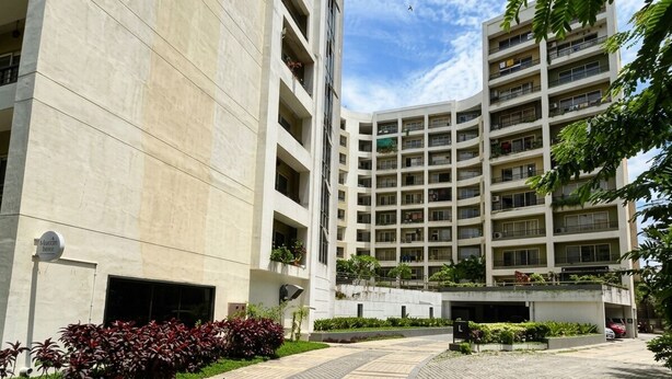 A multi-story hotel with a central courtyard, a parking garage, and a sign indicating a fitness center. - Cityscape, Siddha Xanadu, Newtown: Gym, pool, restaurant, garden, 24/7 security. (Kolkata)
