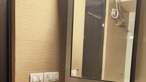 A bathroom with a white sink, a mirror, a towel rack, and a soap dispenser.