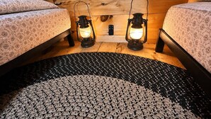 Una habitación acogedora con dos camas, un tapete estampado y dos faroles iluminados.