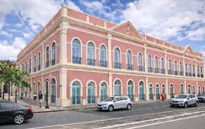A large, multi-story building with a pink facade and arched windows.