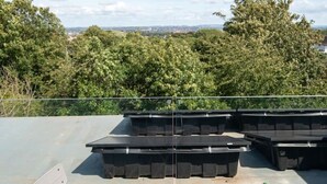 Een dakterras met een gedekte tafel voor twee, omringd door tuinmeubels.