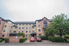 A multi-story hotel with a brick facade, two cars parked in front, and a well-maintained hedge. - Cosy Murrayfield flat - Pass the Keys (Edinburgh)