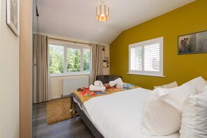 Un dormitorio con cama, ventana, radiador y puerta.