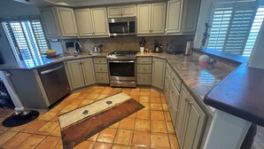 Una cucina con isola centrale, elettrodomestici in acciaio inossidabile e mobili chiari.