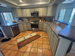 A kitchen with a central island, stainless steel appliances, and light-colored cabinetry. - Ventana Canyon Golf and Racquet Club 2-bedroom townhome (Tucson)