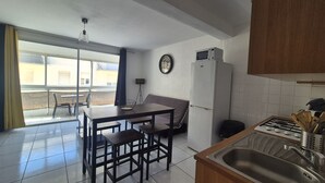 A compact kitchen with a dining area, a refrigerator, a microwave, and a sink. - Studio for 2 people with a loggia and partial sea view. (Canet-en-Roussillon)