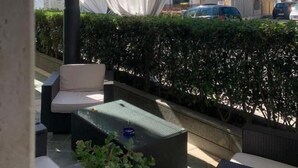 An outdoor seating area with wicker furniture, a table, and a white canopy. - Hotel Ristorante Aeclanum (Mirabella Eclano)
