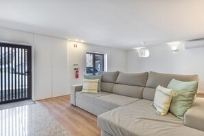 Ein modernes Wohnzimmer mit einer Couch, einem Feuerlöscher und einem Fenster.