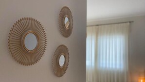Een hotelkamer met een groot bed, een spiegel aan de muur en een raam met gordijnen.