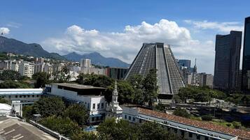 A cityscape with modern buildings, a prominent pyramid-shaped structure, and a mountain in the background.