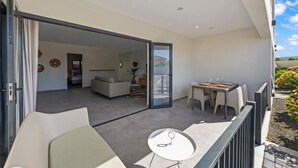 An open-plan living area with a balcony, a dining table, and a sofa. - Apartement Luna Mambo Beach (Willemstad)